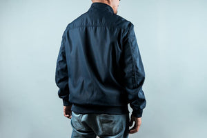 Man wearing a navy sports jacket from behind