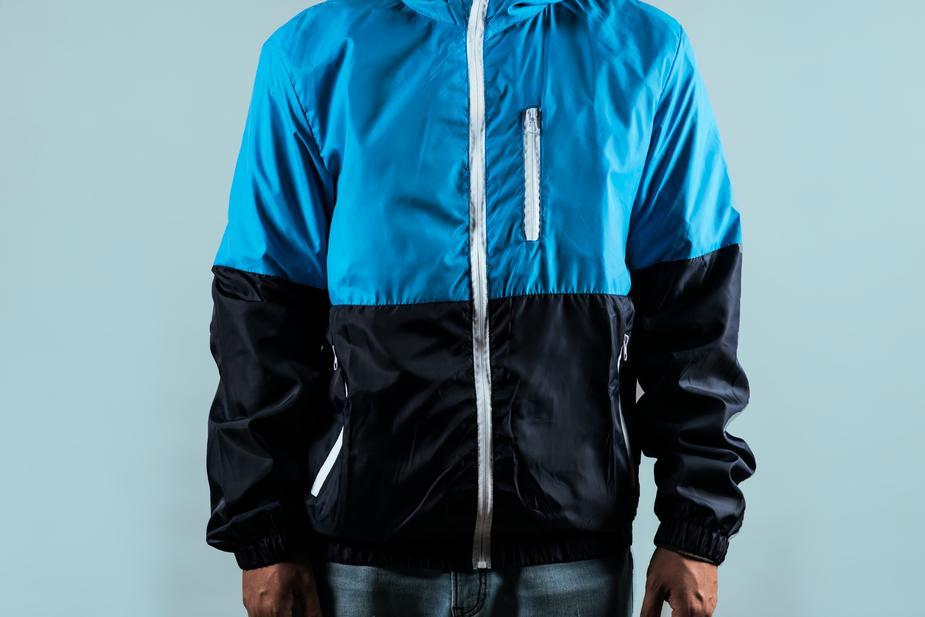 man wearing a half blue and half black zip up sport jacket